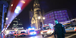 Berliner Breitscheidplatz am 19.Dezember 2016 : Ein Polizist, mehrere Krankenwagen mit Blaulicht hinter einem Absperrband