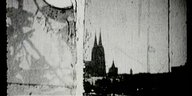 Schwarzweißes Filmbild, beschädigte Oberfläche, erkennbar ist die Silhouette des Kölner Doms