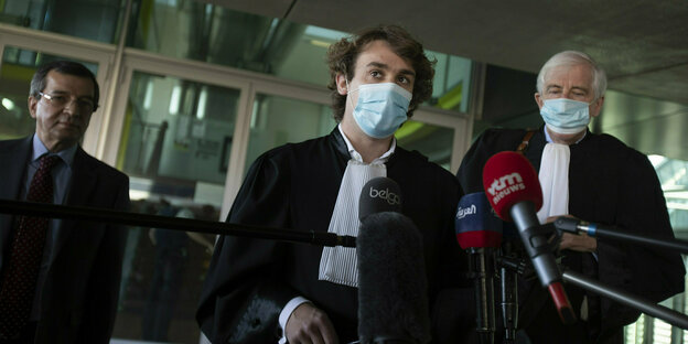 Die Richter George Henri Beauthier und Rik Vanreusel hinter Mikrofonen bei einer Pressekonferenz