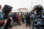Demonstranten stehen in Moskau der Polizei gegenüber- es schneit, ein Mann schreit einen Polizisten an