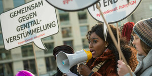 Frauen demonstrieren mit Megafon und Schildern