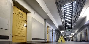 Ein Gang, eine gelbe Zellentür in einem Gefängnis