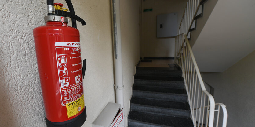 Ein enges Treppenhaus mit Feuerlöscher an der Wand.