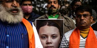 Männer halten ein großes Bild von Greta Thunberg