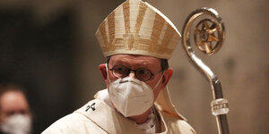 Kardinal Woelki mit Mund/Nasenschutz und Bischofsstab