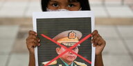 Mädchen mit Bild des Armeechefs von Myanmar.