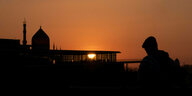 Ein Mann im Gegenlicht während des Sonnenuntergangs vor der Tabakmoschee Yenidze in Dresden