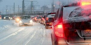 Autos stehen am Stadtrand von Halle/Saale auf einer stark verschneiten Straße im Stau