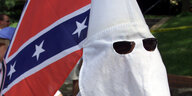 Ein Mitglied des des Ku Klux Klans in Texas im Jahr 2000 mit Konföderierten Flagge, weißer Kapuze und Sonnenbrille