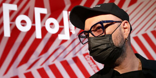 Kirill Serebrennikov sitzt mit roter Mütze in einer Zuschauerreihe