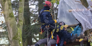 Eine Baumbesetzer wird von den Spezialkräften aus dem Baumhaus abgeseilt.