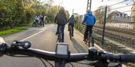 Blick über einen Fahrradlenker auf Radschnellweg Ruhr. Im Hintergrund sind weitere Radfahrer