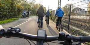 Blick über einen Fahrradlenker auf Radschnellweg Ruhr. Im Hintergrund sind weitere Radfahrer