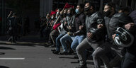 Studierende in Athen mit Gesichtsmasken demonstrieren als geschlossene Menschenkette