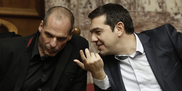 Links Varoufakis der Tschirpas mit zusammengestckten Köpfen zuhört.