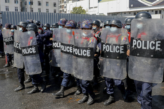 Polizist*innen mit Schutzschildern sind gegen Proteste in Stellung gebracht