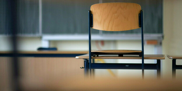 Ein Stuhl steht in einem Klassenzimmer einer Realschule auf einem Tisch.