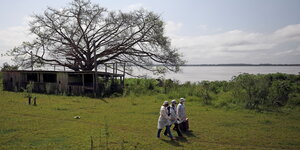 Mitarbeiter der Gesundheitsbehörde in Solimoes auf einer Wiese mit Impfstoffen