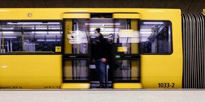 Aus einem gelben U-Bahnzug steigt ein Fahrgast