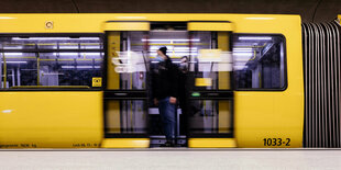 Aus einem gelben U-Bahnzug steigt ein Fahrgast