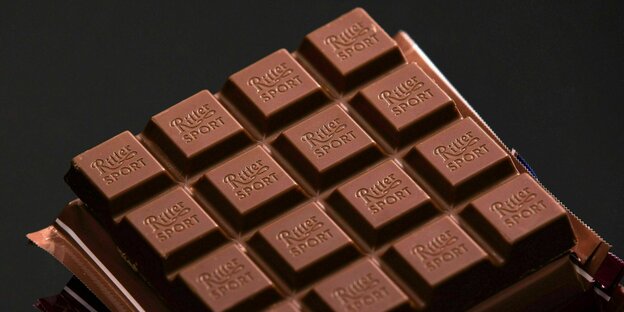 Eine unverpackte Tafel Ritter-Sport Schokolade liegt auf einem schwarzen Hintergrund