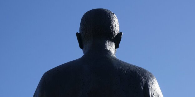 Das Bild zeigt die Rückseite des Kopfes einer Statue des Dichters Bertolt Brecht in Berlin-Mitte vor leuchtend blauem Himmel.