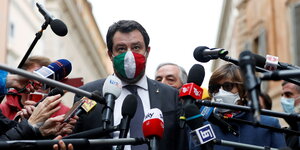 Matteo Salvini trägt bei einem Interview Gesichtsmaske mit Italienflaggenfarben - er ist umringt von zahlreichen Mikrofonen