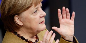 Seitliche Nahaufnahme von Merkel, sie gestikuliert mit erhobenen Händen