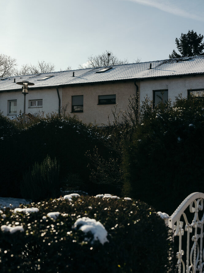 Reihenhäuser hinter einer hohen Hecke