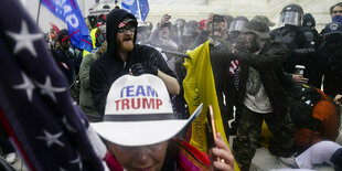 Mit Fahnen und "Team Trump" durchbrechen Anhänger von Trump eine Polizeisperre im Capitol