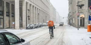 Verschneite Straße mit Radfahrer