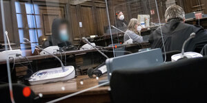 Der mutmaßliche Täter sitzt hinter einer Plexiglasscheibe vor Gericht