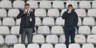 Präsident Vogt und Vorstandsvorsitzender Hitzlsperger stehen auf der Tribüne mit ein paar Meter Abstand zueinander