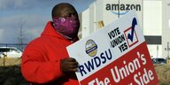 Gewerkschafter mit Schild mit der Aufschrift "Die Gewerkschaft in auf deiner Seite" vor Amazon in Bessemer