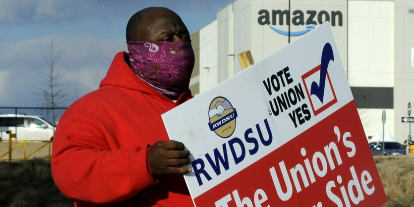 Gewerkschafter mit Schild mit der Aufschrift "Die Gewerkschaft in auf deiner Seite" vor Amazon in Bessemer