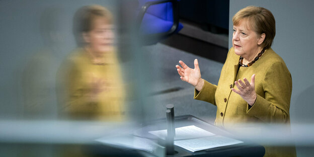 Angela Merkel am Rednerinnenpult in Bundestag, sowie eine Spiegelung von ihr