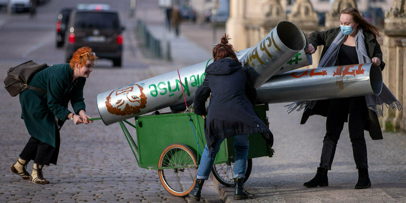 Schwerin: Mitglieder der Bewegung Fridays for Future transportieren eine symbolische Rohrleitung vor den Landtagssitz im Schweriner Schloss. Mit ihrer Aktion protestieren die Umweltaktivisten gegen den Weiterbau der Gaspipeline Nord Stream 2