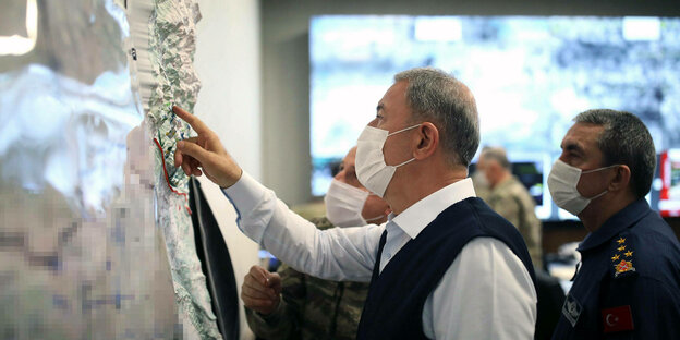 Verteidigungsminister Hulusi Akar steht mit anderen Militärvertretern vor einer Karte und zeigt darauf