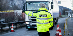 Ein Bundespolizist weist einen LKW-Fahrer in die Grenzkontrollstelle.