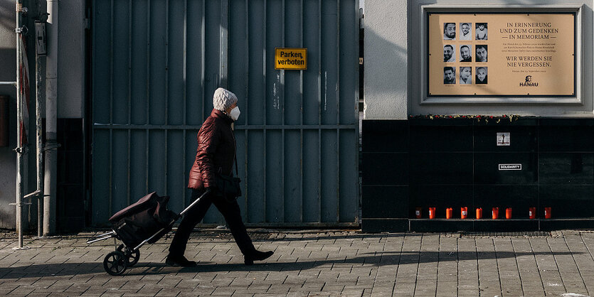 Eine Frau geht an einer gedenkplatte zur Erinnerung an die Opfer von hanau vorbei