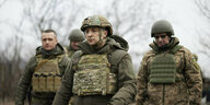 Präsident Wolodimir Selenski beim Truppenbesuch in der Ostukraine läuft Schutzweste und Helm neben Soldaten