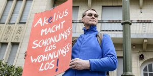Ein Mieter demonstriert gegen Akelius mit einem Schild: Darauf steht: "Akelius macht schonungslos wohnungslos."
