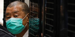 Jimmy Lai kommt mit Mundschutz hinter Gitter hervor