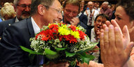 Carsten Sieling bekommt einen Blumenstrauß