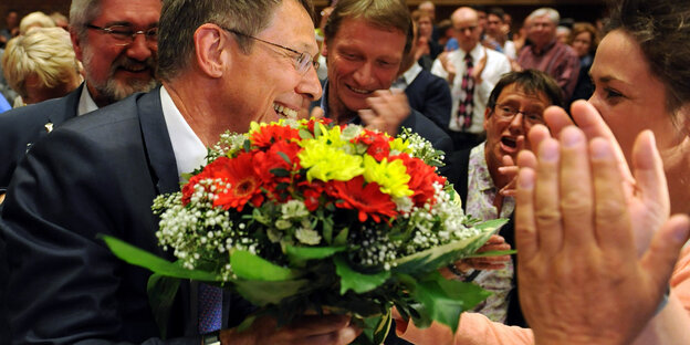 Carsten Sieling bekommt einen Blumenstrauß