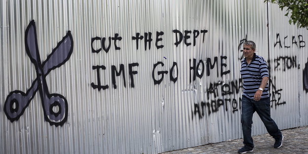 Ein Graffiti in Griechenland mit einer Schere und einem Spruch