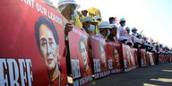 Menschen halten große Schilder, auf denen Freiheit für Aung San Suu Kyi gefordert wird