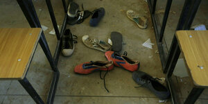 Einzelne Schuhe liegen auf dem Boden einses Klassenzimmers in Kagara