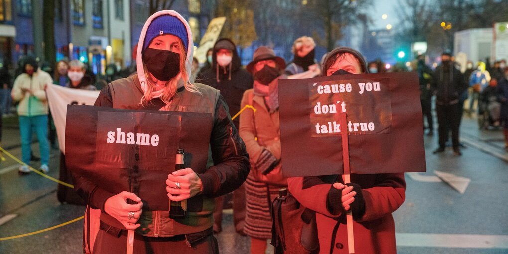 Zwei Frauen halten auf einer Demonstration gegen das geplante Neubauprojekt Paulihaus zwei Schilder mit den Aufschriften "Shame" und "cause you don't talk true".