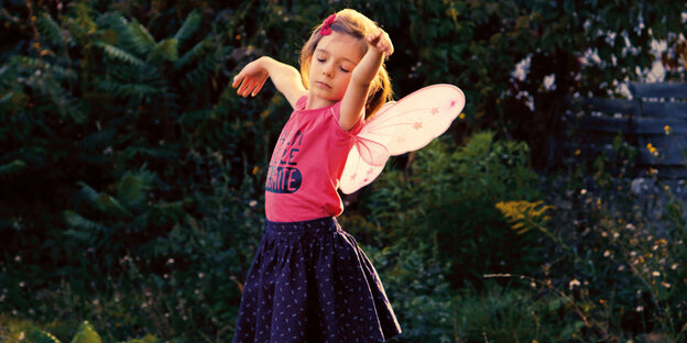 Ein Kind mit Schmetterlingsflügeln tanzt